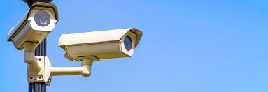 Weatherproof outdoor bullet camera with a protective hood.